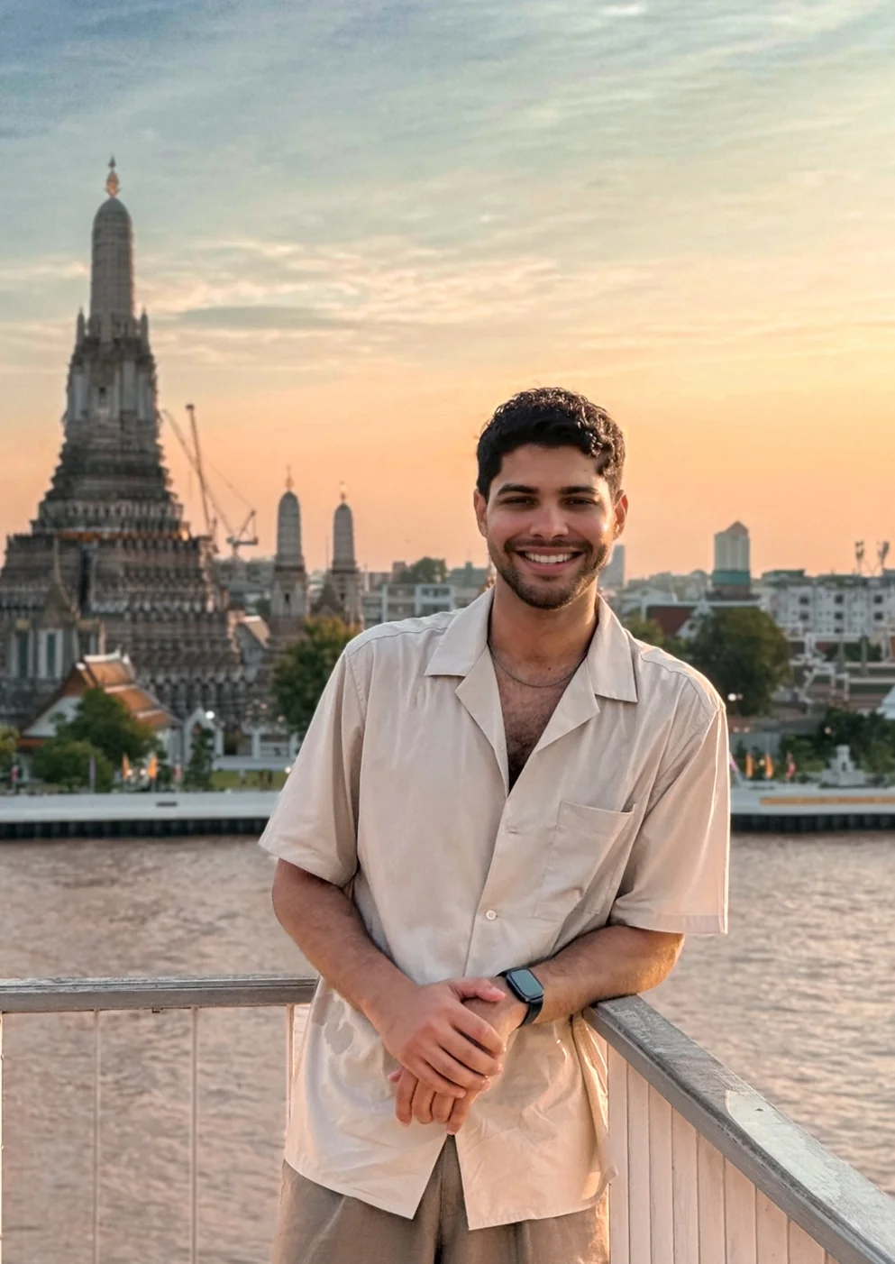 Ricardo frente al río y un templo al atardecer